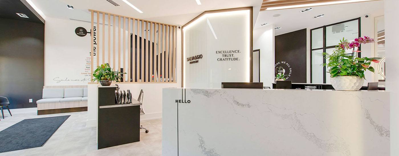 The Salvaggio Dentistry reception with marble desk and warm wood details